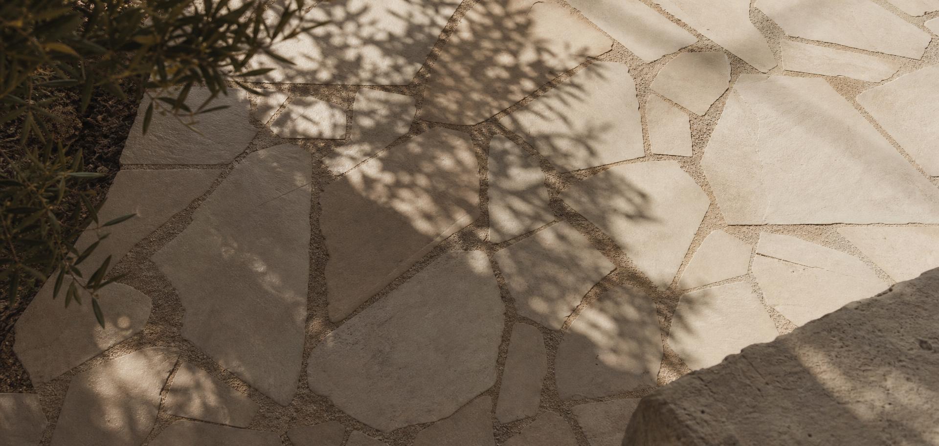 Overhead architectural crazy paving with dappled olive shadows