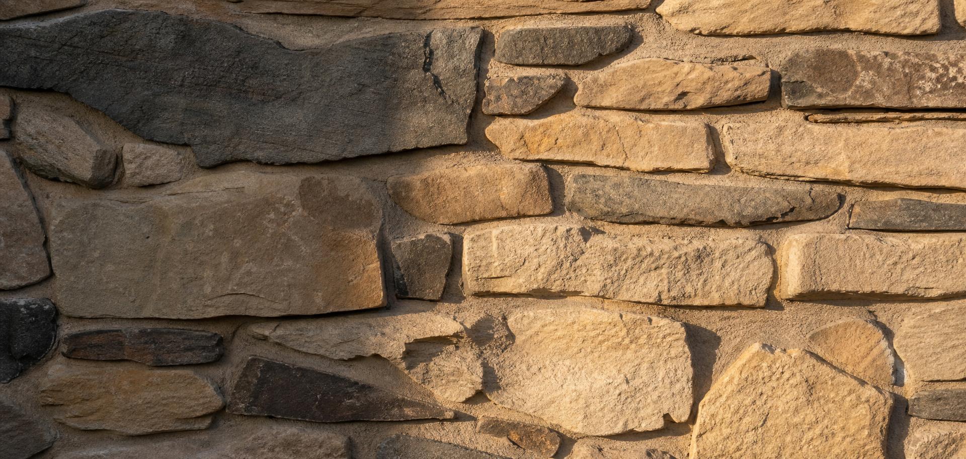 Hand-built natural stone wall in warm raking light